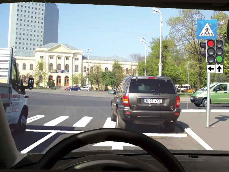 Autovehiculul din faţa dvs. traversează intersecţia. Cum veţi proceda?